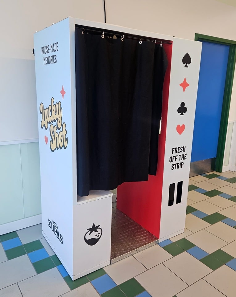 Casino-themed photo booth with a black curtain, white panels, and 'Fresh Off the Strip' text.